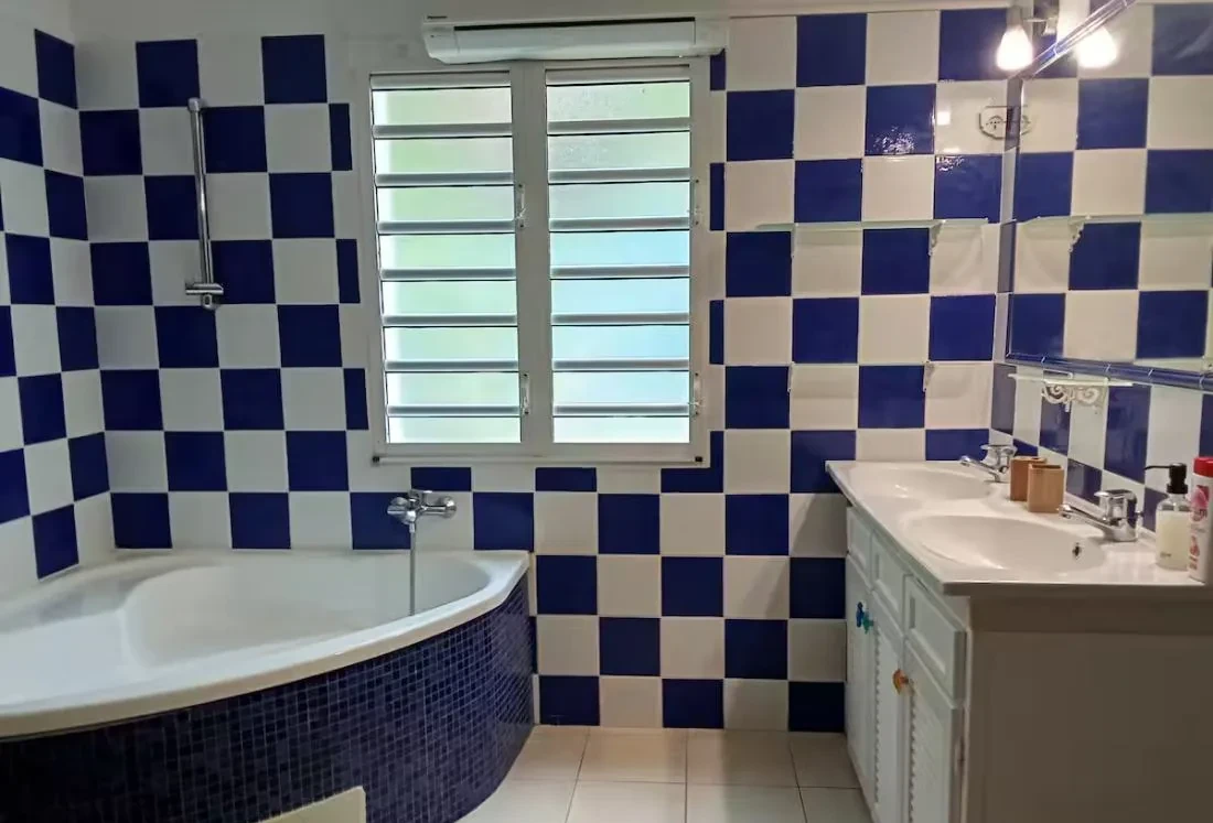 Salle de bain en carreaux bleu et blanc avec baignoire d'angle